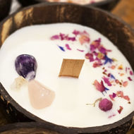 Hand-poured coconut-shell candle with wooden wick, scented with ylang ylang and rosewood, presented as the “Tropical Bloom” aromatherapy candle.